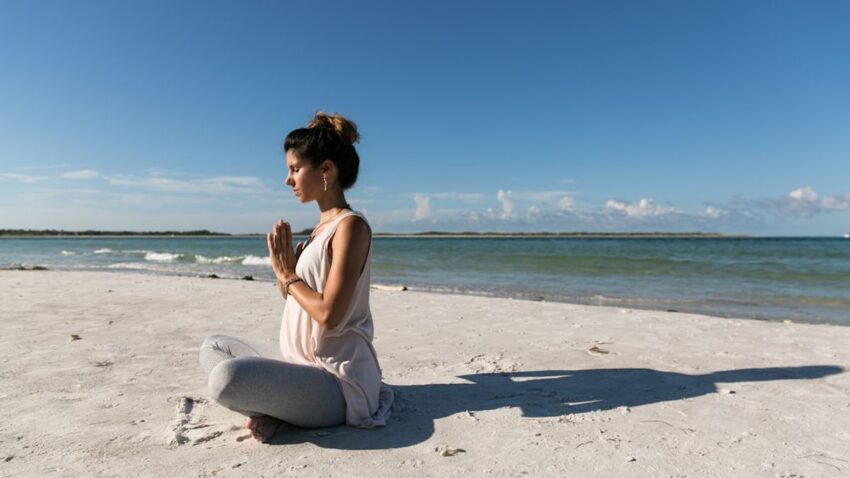 Una donna pratica il grounding in un bosco, connettendosi con la natura per alleviare lo stress e l'ansia.