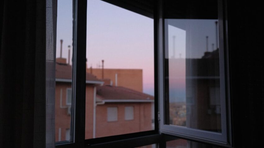 Una donna rilassata si prepara per la notte seguendo la sua routine serale in una camera da letto accogliente e illuminata da una luce soffusa.