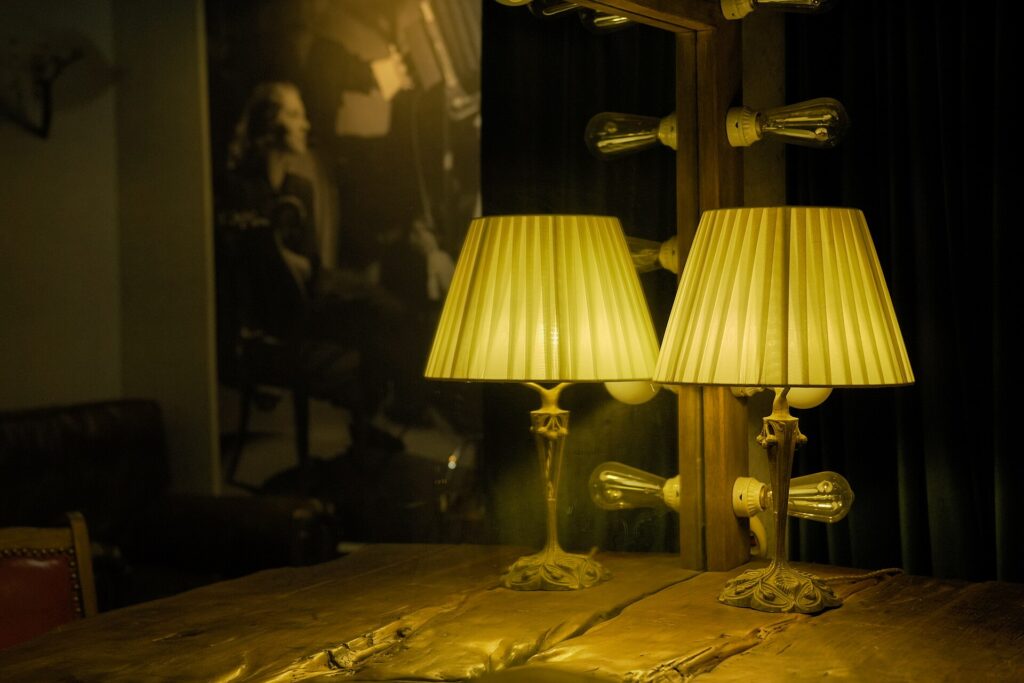 Lampada da tavolo accesa su una scrivania ingombra di fogli a tarda sera