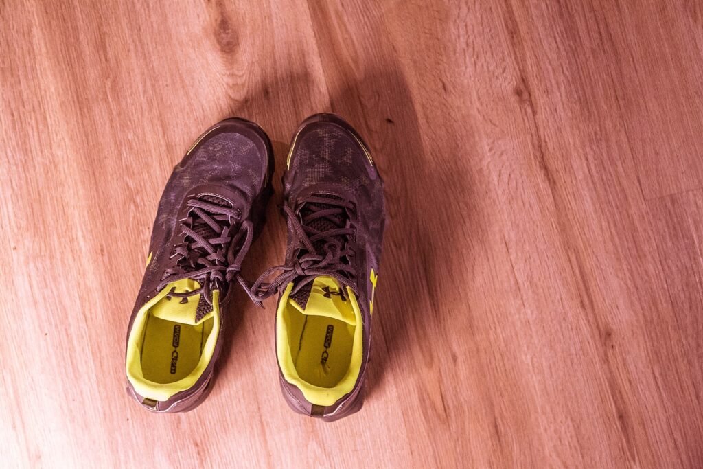 Scarpe da corsa appoggiate sul pavimento accanto alla porta di ingresso di casa
