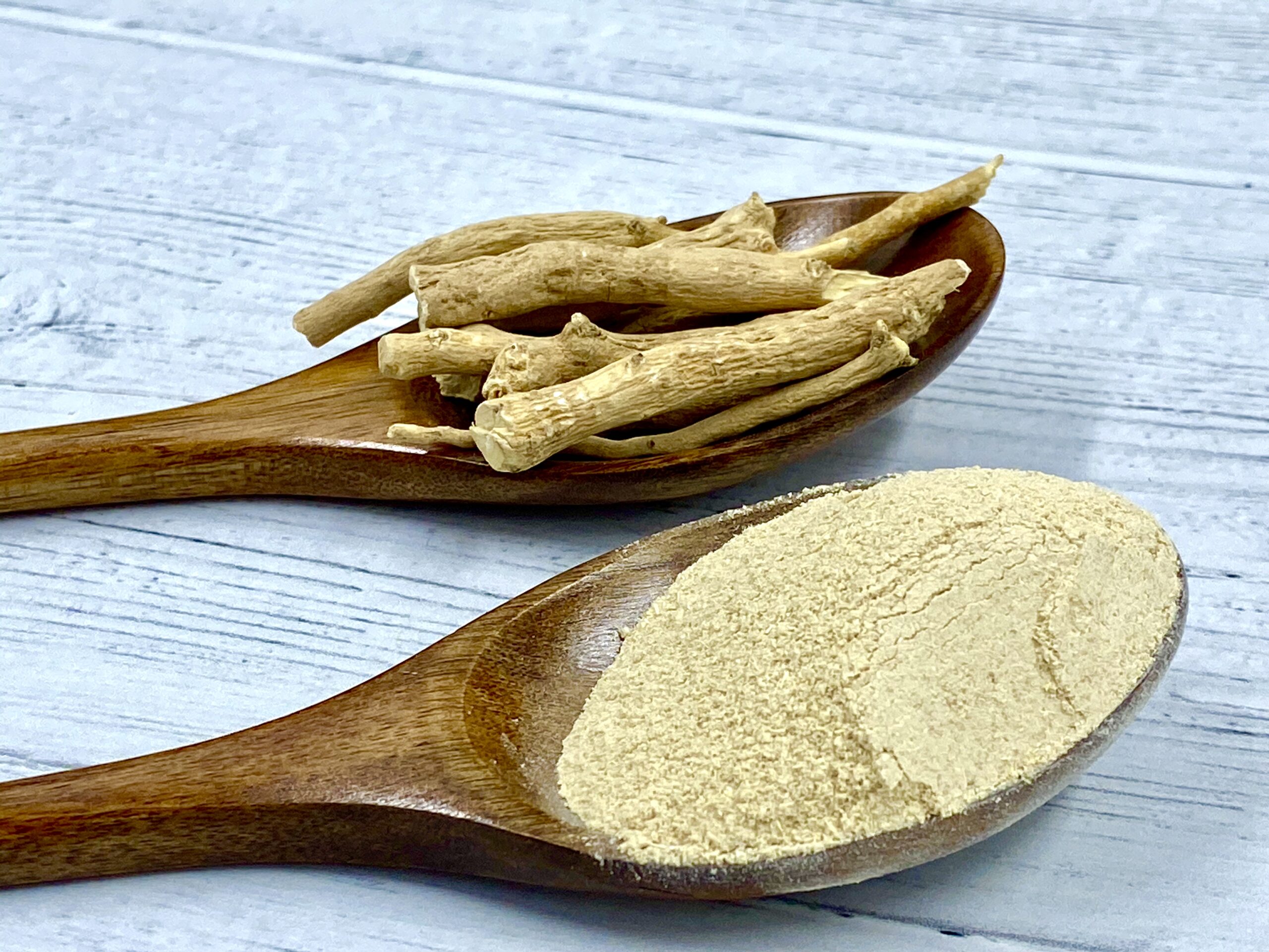 Radice essiccata e polvere chiara disposte in due ciotoline su un piano di legno