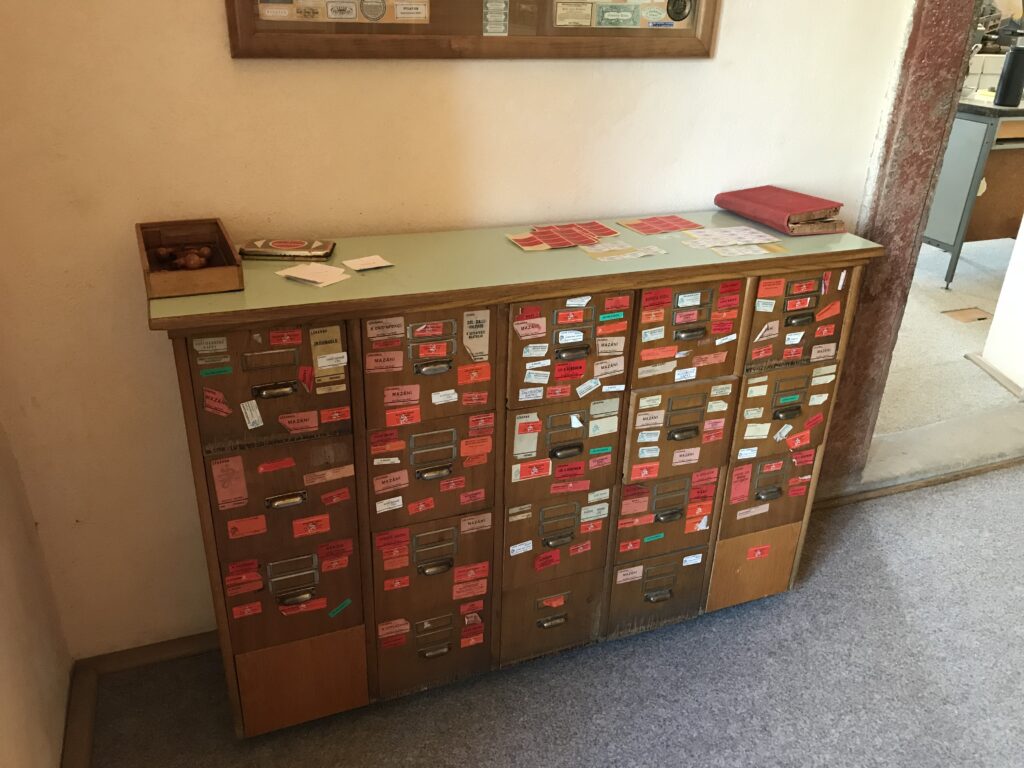 Scaffale di farmacia con confezioni allineate e cartellini dei prezzi in vista
